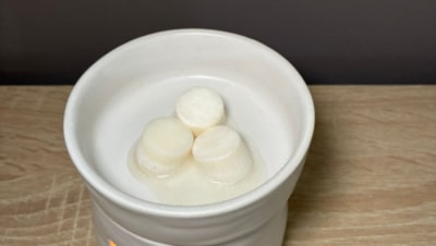 melts aromáticos de cera de soja derritiéndose en un quemador de cerámica