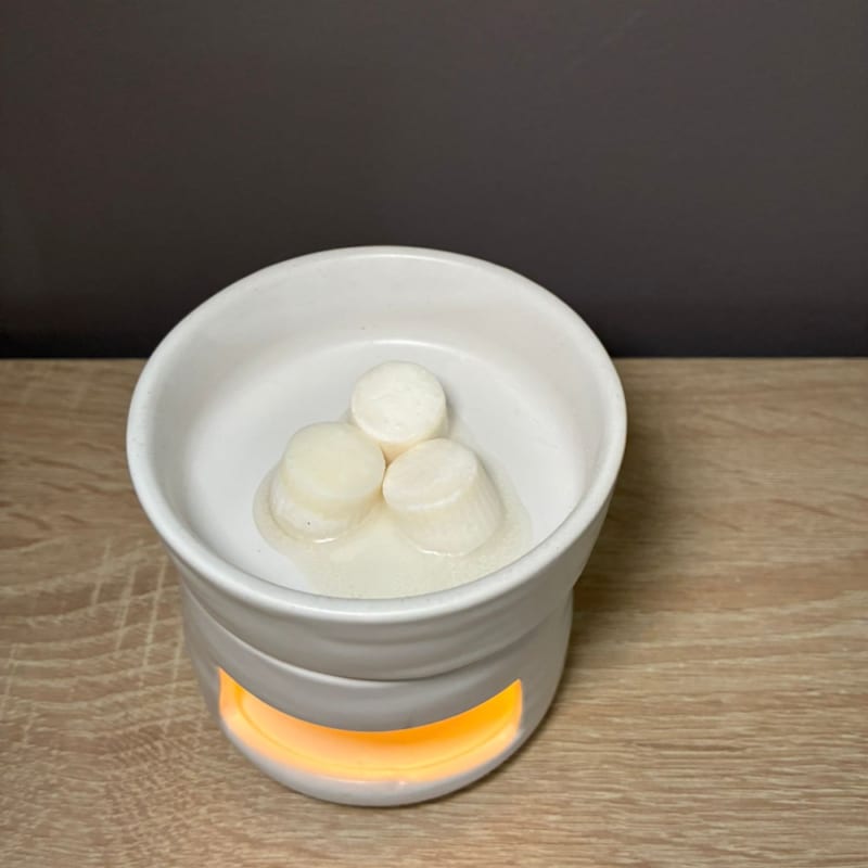 melts aromáticos de cera de soja derritiéndose en un quemador de cerámica